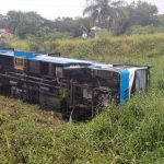 ônibus tombado de lado no meio de um terreno