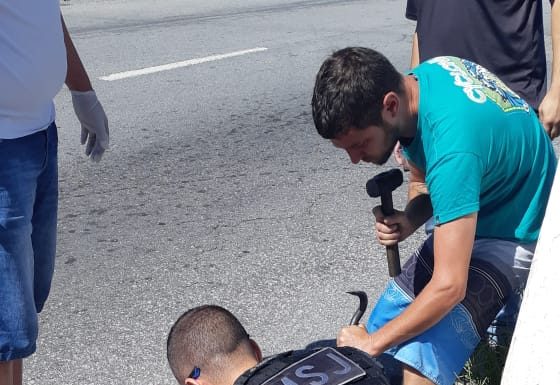 Homem retirando cachorro de boeiro