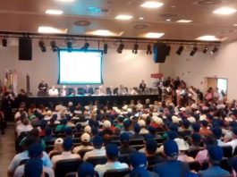 Com Alesc lotada, deputados pressionam governo para prorrogação do incentivo aos agrotóxicos auditório lotado com maioria de homens de boné azul e outros brancos e no palco deputados em bancada