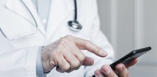 médico discando em um telefone celular