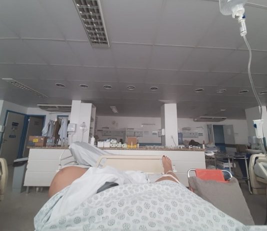 Pacientes do Hospital Regional de São José sofrem com ar condicionado quebrado mulher deitada em cama de hospital com os pés para frente em enfermaria vazia