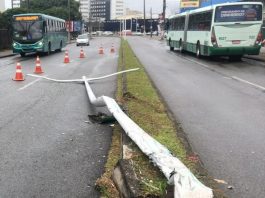 poste caído no canteiro central da avenida com cones delimitando e ônibus da jotur ao fundo e outro do outro lado