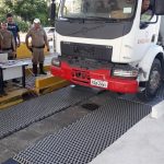 caminhão estacionando sobre a balança com policias em volta