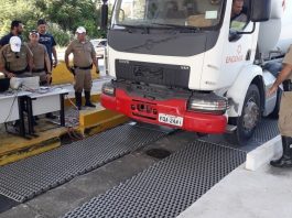 caminhão estacionando sobre a balança com policias em volta