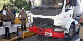 caminhão estacionando sobre a balança com policias em volta