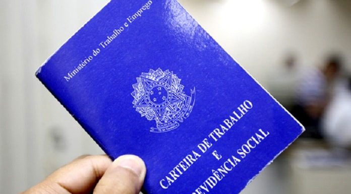 pessoa segurando carteira de trabalho e previdência social