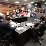 deputados reunidos em bancada na comissão da alesc em pequeno auditório