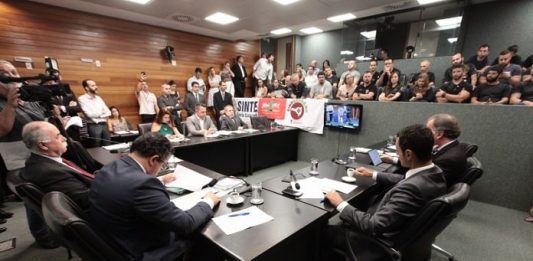 Lei que proíbe ingresso na Udesc para quem usou drogas ilícitas avança na Alesc deputados reunidos em bancada na comissão da alesc em pequeno auditório