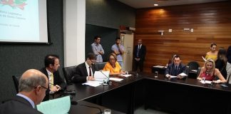 deputados reunidos em volta de uma bancada preta quadrada em pequeno auditório da alesc