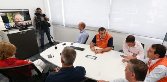 Moisés confirma 109 casos de Covid-19 em Santa Catarina e fala sobre conversa com Bolsonaro moisés e equipe reunidos ao redor de mesa olhando para uma tv onde está o ministro paulo guedes