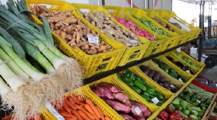 caixas com diversos legumes em feira