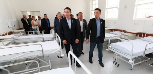 moisés anda no meio de sala com macas seguido por outras pessoas