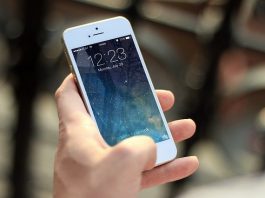 Vender celular sem adaptador de tomada não é prática comercial abusiva, entende juiz close em pessoa segurando um iphone com tela ligada