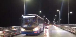 ônibus do transporte coletivo municipal saindo da ponte hercílio luz à noite com viatura atrás