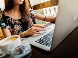 Em média, mulheres têm salário 26% menor do que homens em SC mulher trabalhando no notebook com xícara de café ao lado