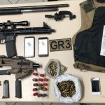 espingarda, metralhadoras, armas e munições organizadas sobre uma mesa