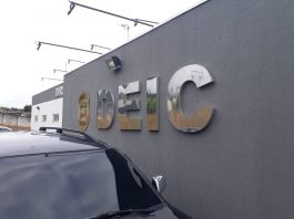 fachada da deic com inscrição na parede externa em grandes letras; carro estacionado