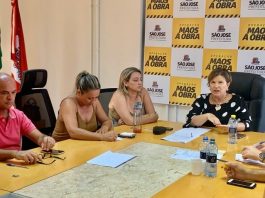Em São José, prefeita Adeliana reúne secretariado para estabelecer ações contra o Coronavírus prefeita e secretárias reunidas em volta de uma mesa e painel com logos de são josé ao fundo