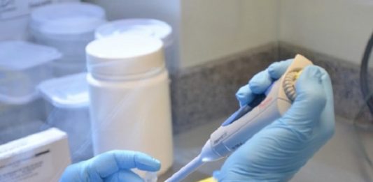 pessoa manipula ampolas com luvas