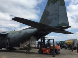 avião cargueiro do exército com empilhadeira atrás tirando carga