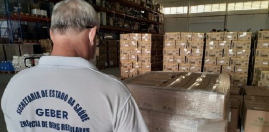 Homem conferindo carga de testes rápidos