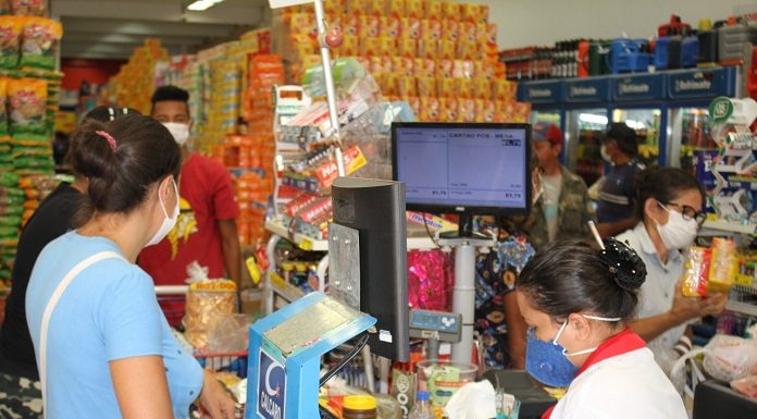 Pessoa usando máscara no caixa de supermercado