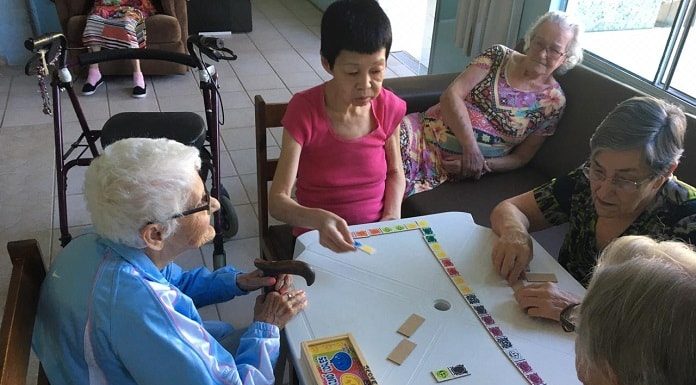 grupo de idosas jogando dominó sobre mesa de plástico