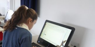 aluna sentada mexendo em computador
