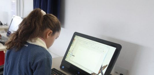 aluna sentada mexendo em computador