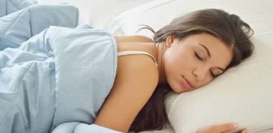 Dicas para melhorar a qualidade do sono mulher dormindo em uma cama, coberta com um cobertor azul