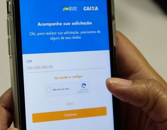 pessoa segura celular com aplicativo da caixa aberto na tela