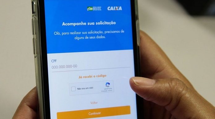 pessoa segura celular com aplicativo da caixa aberto na tela