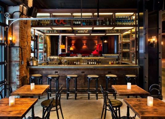 bar com mesas e cadeiras e banquinhos em frente a um balcão