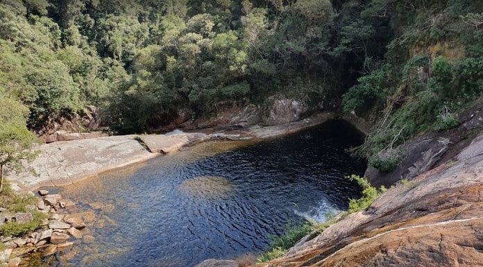 foto de cima da cachoeira mostrando a queda d'água, pedras e mata em volta