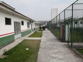 Justiça afasta 12 agentes do Case de São José foto de uma calçada em um pátio no interior do case, com agentes ao fundo; de um lado prédio, do outro grades