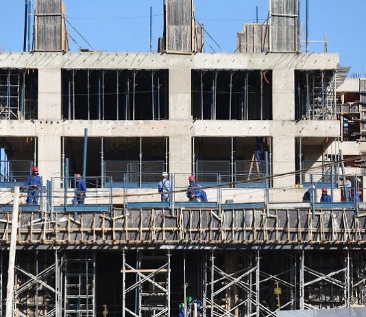 operários em um prédio em construção
