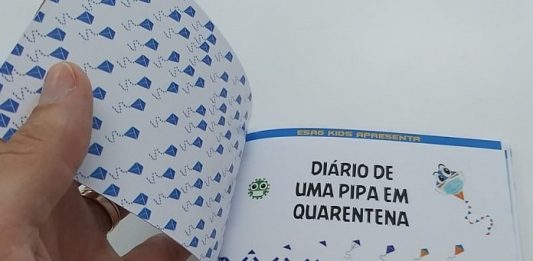Programa da Udesc inclui livros infantis em mais de mil cestas básicas para famílias pessoa abre o livro "Diário de uma Pipa em Quarentena"