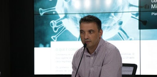 Alesc pede afastamento do secretário de Saúde e abre CPI zeferino fala ao microfone com outros microfones de imprensa sobre bancada e telão ao fundo