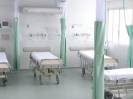 quatro camas de hospitais separadas por cortinas recolhidas
