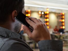 Celesc alerta para novos golpes por telefone homem visto de costas falando ao celular