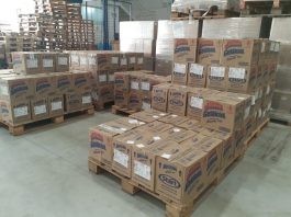 dezenas de caixas empilhados sobre pallets em galpão