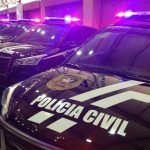 viaturas suv da polícia civil em galpão com sinais luminosos ligados