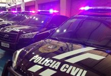 viaturas suv da polícia civil em galpão com sinais luminosos ligados