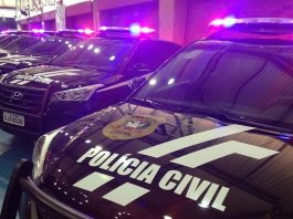 viaturas suv da polícia civil em galpão com sinais luminosos ligados