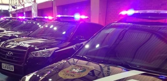 viaturas suv da polícia civil em galpão com sinais luminosos ligados