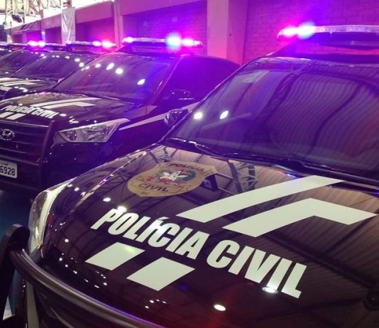 viaturas suv da polícia civil em galpão com sinais luminosos ligados