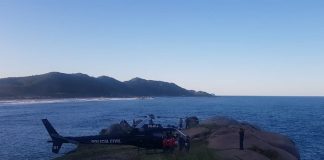 helicóptero pousado em um costão da praia mole