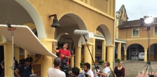 profissionais em set de filmagem da série, mexendo em equipamentos de filmagem