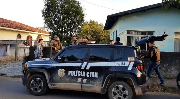 jeep renegade da polícia civil parado em frente de uma casa com polícias e outros homens em volta