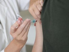 Adultos e professores podem tomar a vacina contra gripe a partir desta segunda pessoa aplica injeção de vacina no braço de outra